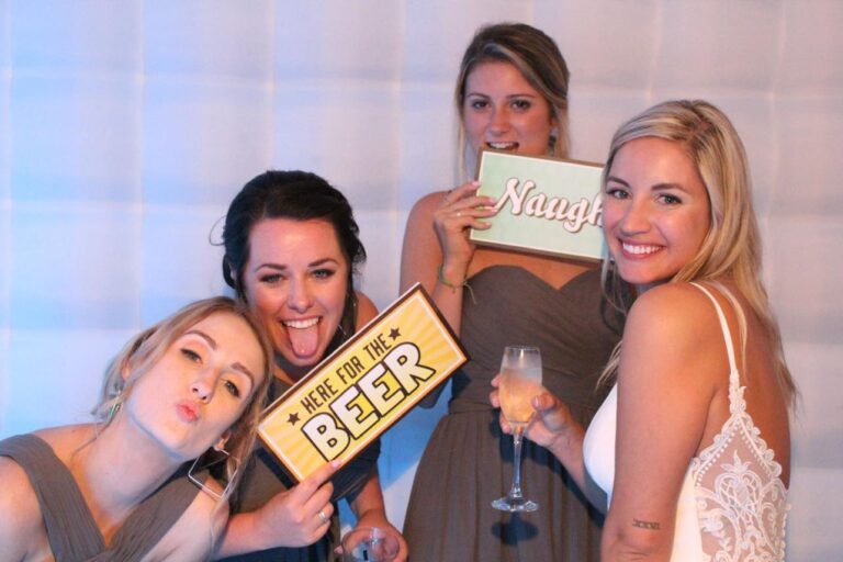 Four women pose playfully at selfie photo booth houston