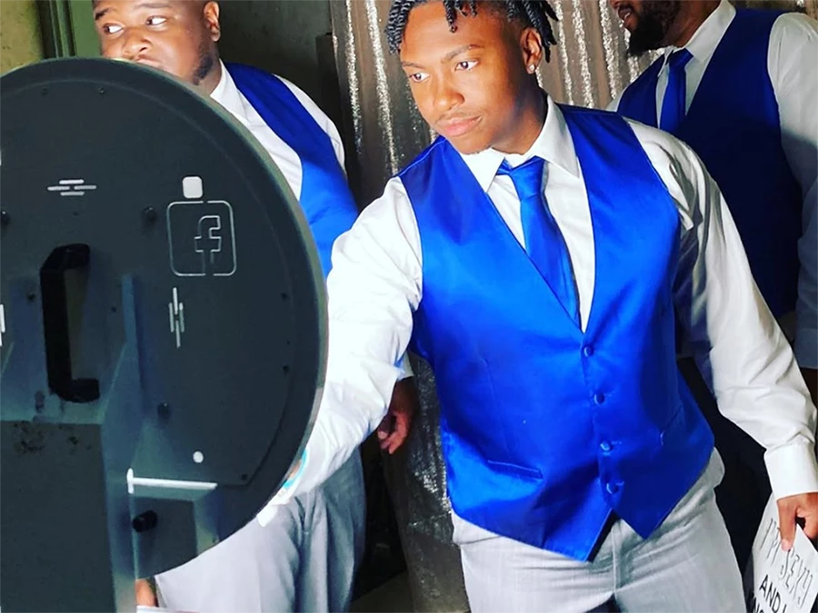 Guests using 360 Video Booth Rental in Central Business District, dressed in blue vests at an event